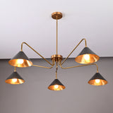 Angled view of modern 5-light brass cone chandelier with warm illumination and sleek sculptural brass frame.