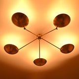 Warm ambient ceiling glow from a 5-light brushed brass chandelier with bowl-shaped uplighting shades