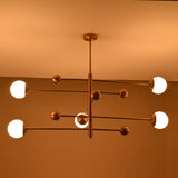 Warm ambient glow from a 5-light brass chandelier featuring opal globes and sculpted linear brass arms.