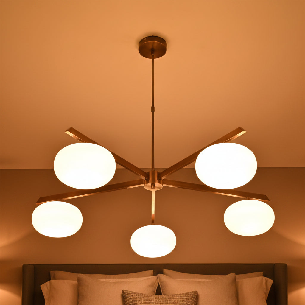 5-light chandelier with oval opal glass balls, brass arms, and clean modern ceiling-mounted design