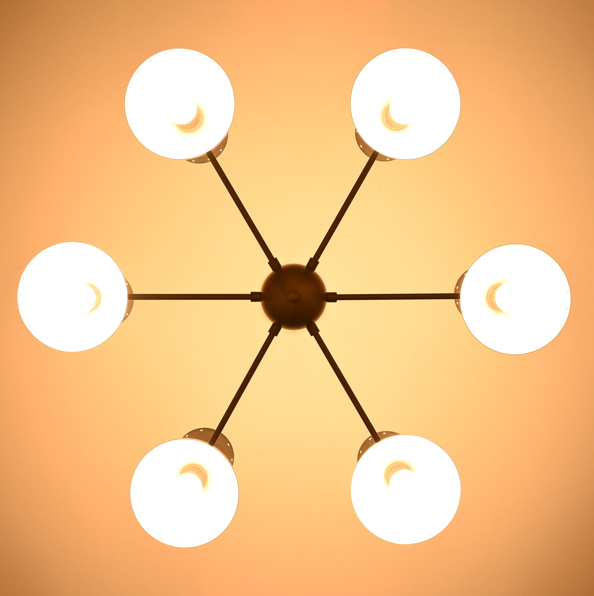 Underside view of illuminated 6 Brass Diabolo chandelier highlighting warm indirect lighting and solid brass construction