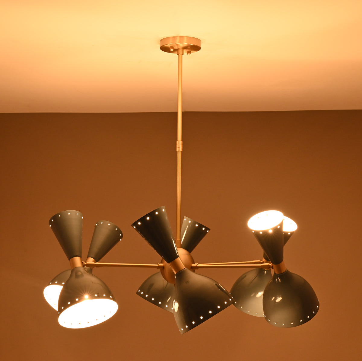 6 Brass Diabolo 12-light chandelier illuminated with warm ambient glow, modern brass lighting by Brass Leaf Studio