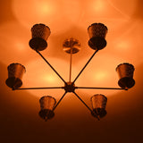 6 light brass chandelier emitting warm ambient lighting through perforated cone shades, ideal for dining and living spaces.