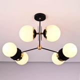 Close-up detail of opal glass globe shades and solid brass hardware on a modern industrial chandelier.