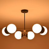 Modern industrial brass chandelier with six opal glass globes enhancing ambient lighting in an elegant interior.