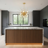 A modern suncatcher chandelier with a gold-finished metal frame, featuring multiple thin radiating rods and white frosted globe bulbs, suspended from a matching circular ceiling canopy against a solid white background.