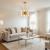 A modern suncatcher chandelier with a gold-finished metal frame, featuring multiple thin radiating rods and white frosted globe bulbs, suspended from a matching circular ceiling canopy against a solid white background.