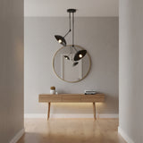 A modern black dual-light pendant ceiling fixture with two adjustable conical shades suspended from a round ceiling canopy on a plain white background.