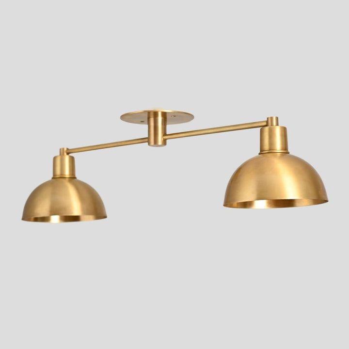 Handmade brass ceiling light fixture with two dome shades in brushed finish.