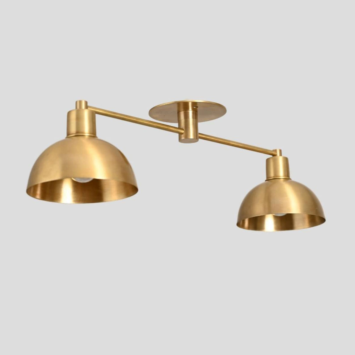 Industrial-style brass double dome ceiling light for contemporary interiors.