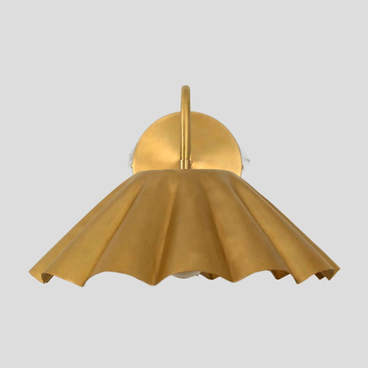 Front view of golden brass pleated shade wall sconce with sculptural shade design.
