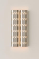 Decorative wall sconce with geometric pattern on a light gray background