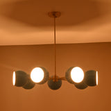 Symmetrical 7 bowl brass chandelier with blue glass shades installed in contemporary space