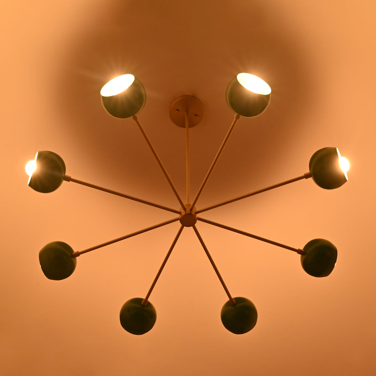 7 bowl green brass chandelier illuminated with warm ambient light creating soft indirect ceiling glow