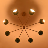 7 bowl green brass chandelier illuminated with warm ambient light creating soft indirect ceiling glow