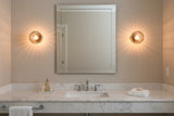 8 inch ribbed glass globe wall sconce with brass accent hardware shown in close-up front view