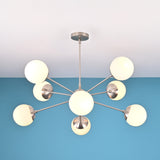 Modern 8 light brass globe chandelier with opal glass shades and balanced mid century silhouette