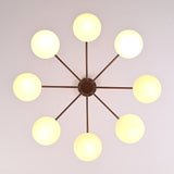 Top view of 8-light brass chandelier featuring evenly spaced opal glass globes arranged in a radial mid-century modern pattern.