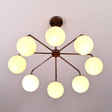 Mid-century style brass chandelier featuring eight glowing opal globes arranged in a sculptural radial design.