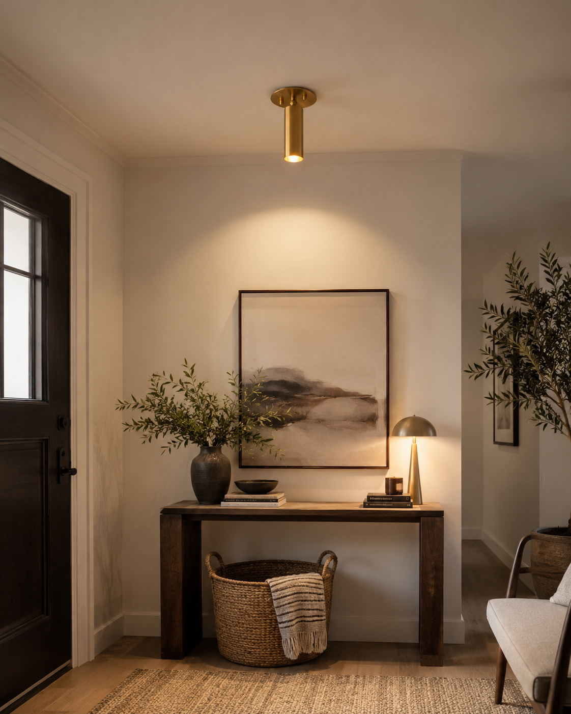 Alden adjustable brass ceiling spotlight installed on a modern ceiling, providing warm accent lighting in a contemporary entryway.