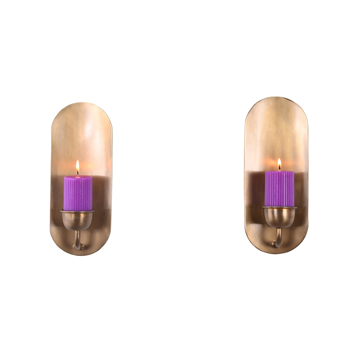 Front view of the Alden modern brass candle wall sconce featuring a lit purple pillar candle on an elongated brass backplate.