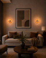 Two Alden Modern Dome Wall Sconces installed on a contemporary living room wall, providing warm accent lighting beside framed artwork.