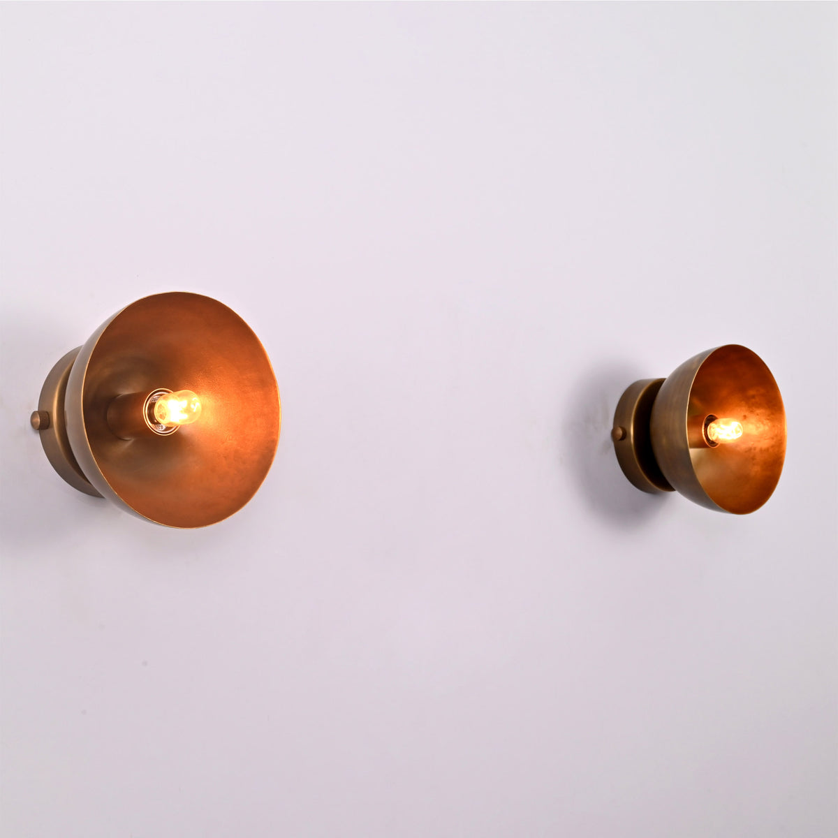 Angled perspective view of two Alden Modern Dome Wall Sconces highlighting the smooth dome profile and exposed bulb design.