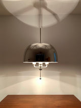 Illuminated Alexandria polished chrome dome pendant featuring a reflective hemispherical metal shade, exposed bulb arrangement, slender suspension, and warm ambient lighting.