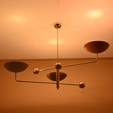 Multicolor brass ceiling chandelier radiating warm light with subtle reflections, perfect for artistic modern interiors.