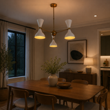 Amsterdam 6 light white and brass double cone chandelier illuminated above a modern dining table in a warm contemporary interior.