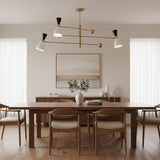 Aspen 6 light counterbalance chandelier shown from an angled view with perforated white cone shades, black accents, and brass-tone spherical counterweights.