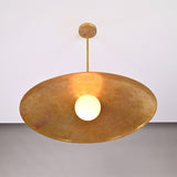 Close up of Aurelia Globe Saucer Pendant Light with warm globe illumination beneath the wide shade.