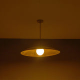 Wide evening view of Aurelia Globe Saucer Pendant Light highlighting the warm globe bulb and dome profile.
