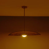 Side view of Aurelia Globe Saucer Pendant Light showing low saucer silhouette and downward warm glow.