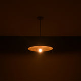 Wide view of Aurelia Petite Saucer Pendant Light illuminated in low light with soft ambient glow.