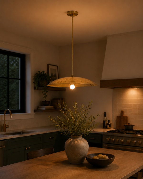 Aurelia Petite Saucer Pendant Light installed above a kitchen island in a warm modern interior.
