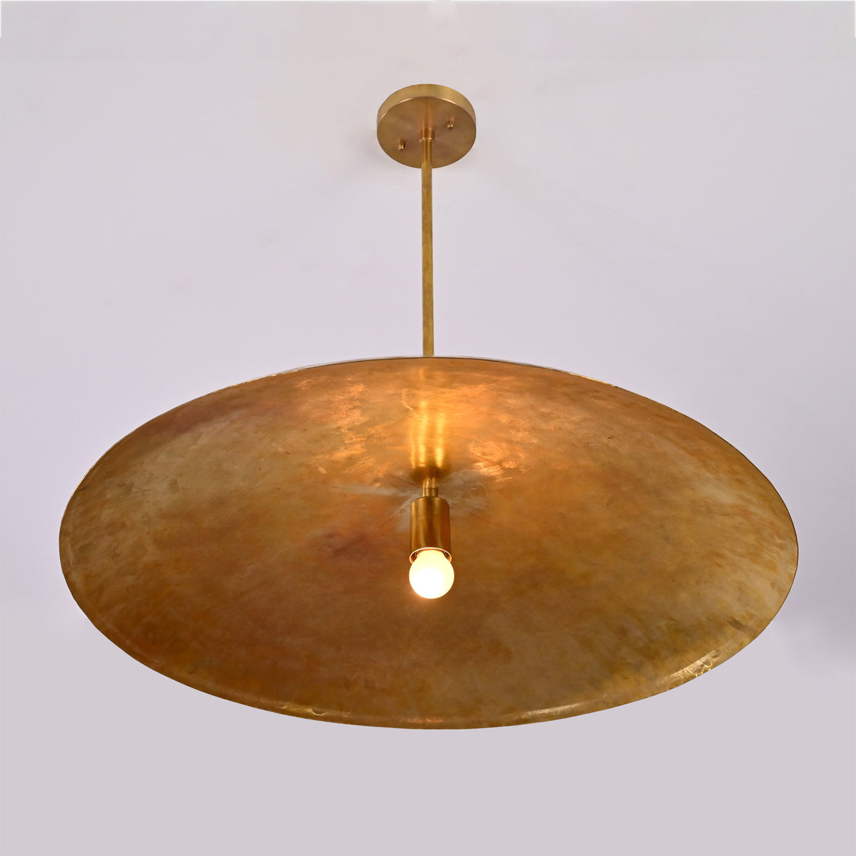 Close up of Aurelia Saucer Pendant Light showing broad saucer shade and warm central illumination.