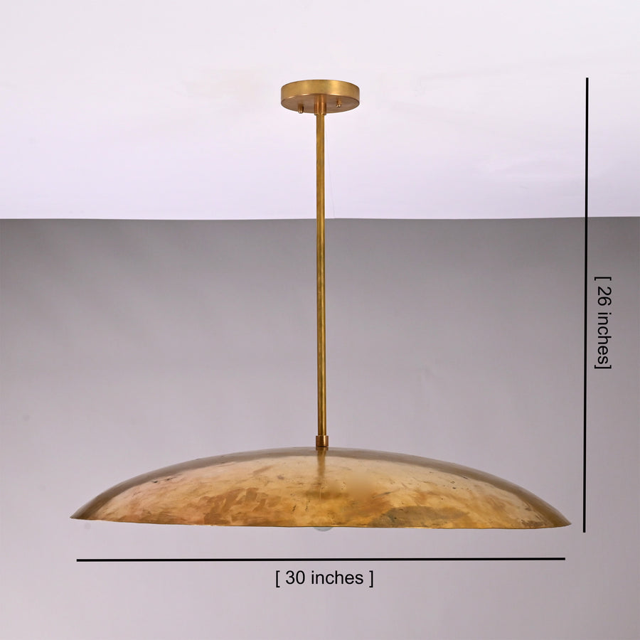 Aurelia Saucer Pendant Light installed above a round dining table in a warm modern interior.