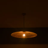 Aurelia Saucer Pendant Light glowing in a dark setting with soft downward ambient light effect.