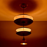 Close view of Aurelia Tiered Disc Chandelier showing layered round shades and warm ambient illumination.