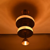 Low angle view of Aurelia Tiered Disc Chandelier with illuminated stacked discs and pendant-style lower shade.
