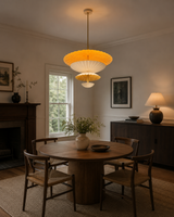 Aurora 24 inch layered petal pendant chandelier displayed above a round dining table in a warm modern dining room.
