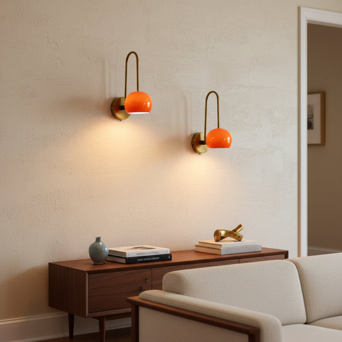 Set of two Aurora Loop Dome Wall Sconces featuring orange dome shades and curved brass frames – Model 32831