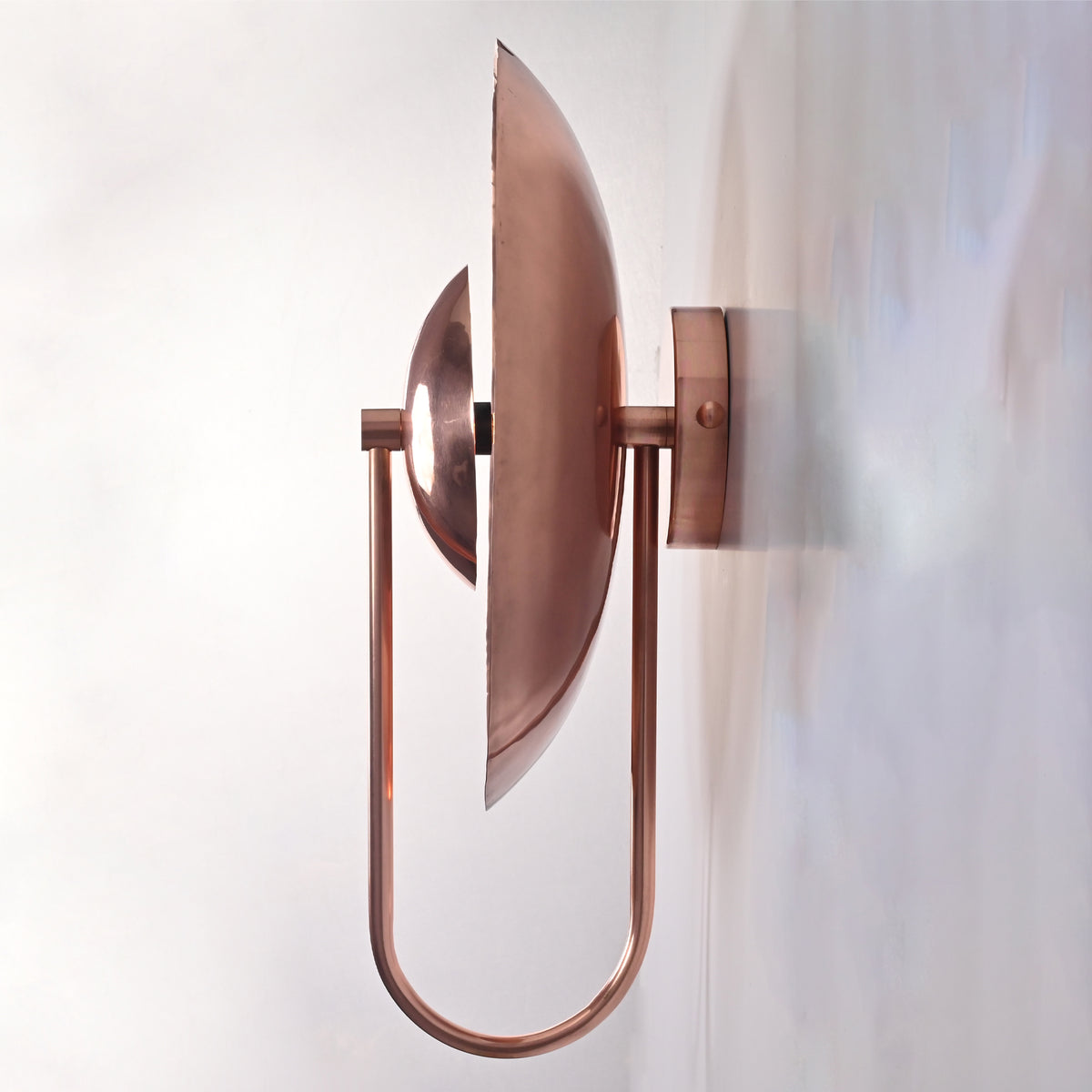 Front view of the Aurora modern copper halo wall sconce featuring a sculptural circular reflector with a polished copper finish and a sleek central dome.