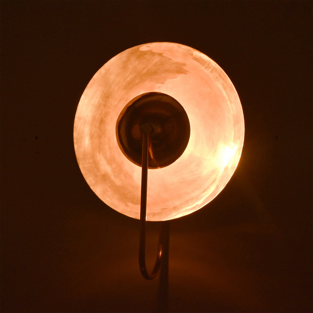 Illuminated side view of the Aurora modern copper halo wall sconce featuring a polished copper reflector with elegant indirect lighting.