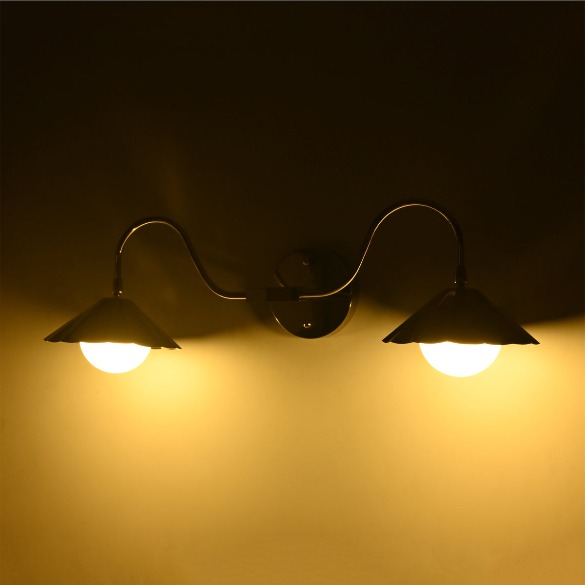 Angled illuminated view of the Aurora modern polished nickel double wall sconce highlighting the curved arms, fluted metal shades, and warm ambient glow.