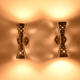 Pair of Aurora perforated double cone wall sconces creating decorative light patterns with warm ambient illumination.