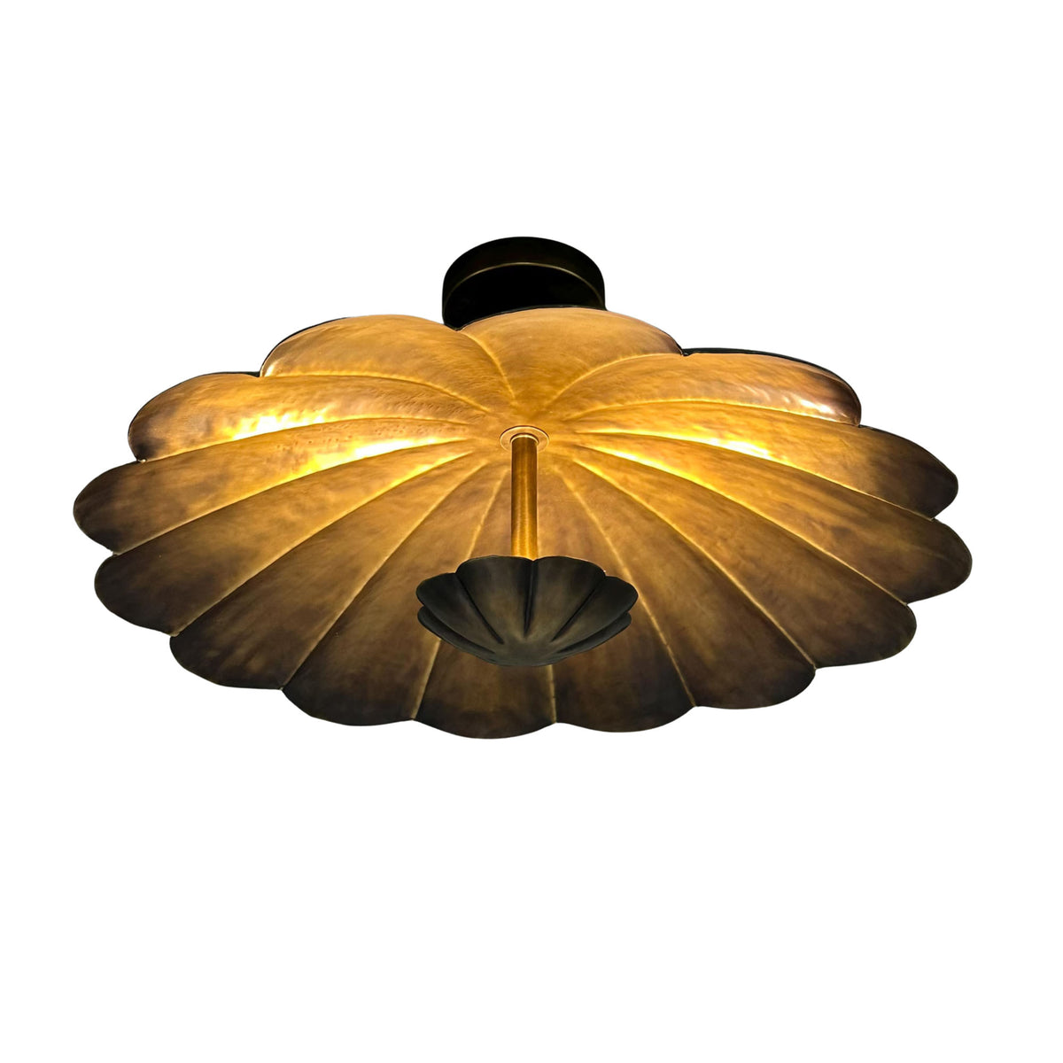 Angled view of Aurora petal flush mount with warm illumination across the sculpted metal flower shade.