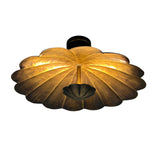 Angled view of Aurora petal flush mount with warm illumination across the sculpted metal flower shade.