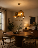 Aurora Sculptural Disc Chandelier installed above a modern dining table, featuring four exposed globe bulbs, handcrafted brass disc reflectors, and warm ambient lighting in a contemporary dining room.